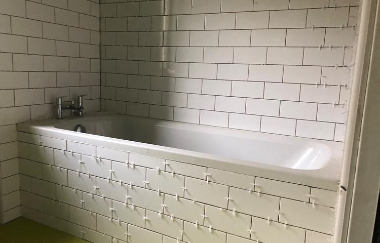 Bathroom bathtub with white wall tiling in progress in Lewisham