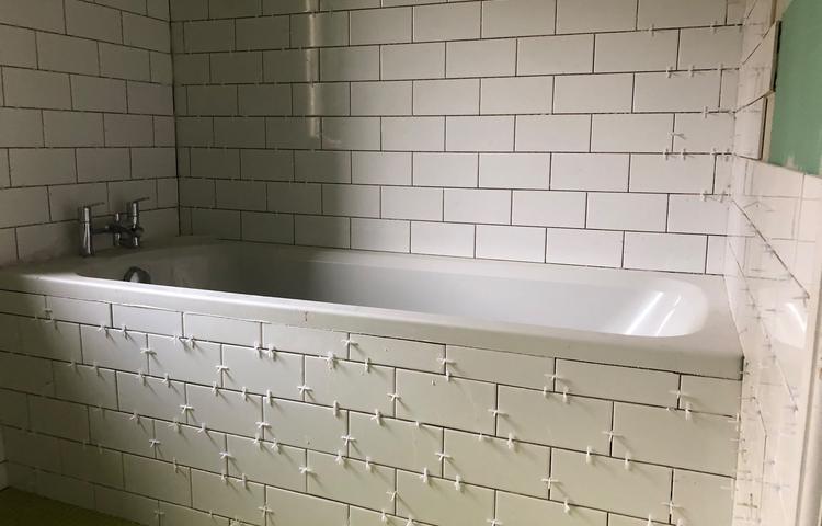 Bathtub and tiled bathroom walls in Lewisham