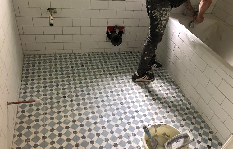 Patterned bathroom floor tiles being laid in Lewisham