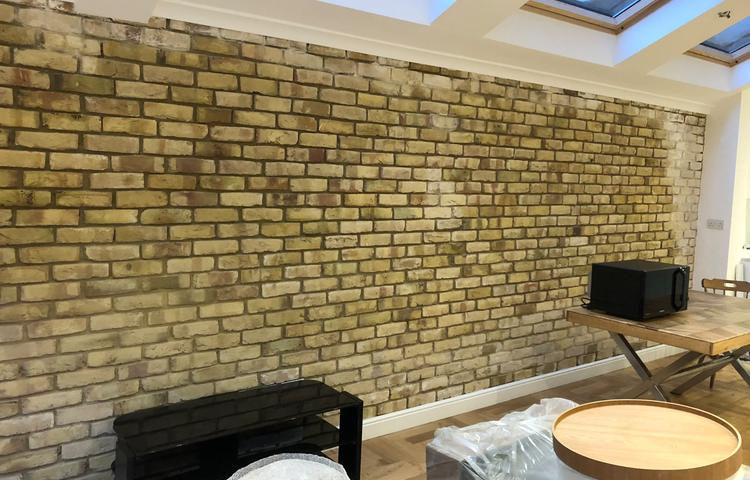 Exposed brick feature wall beneath rooflights in Lewisham