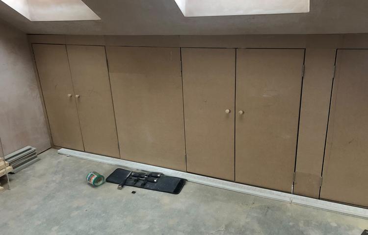 Fitted storage cabinets beneath rooflights in Lewisham