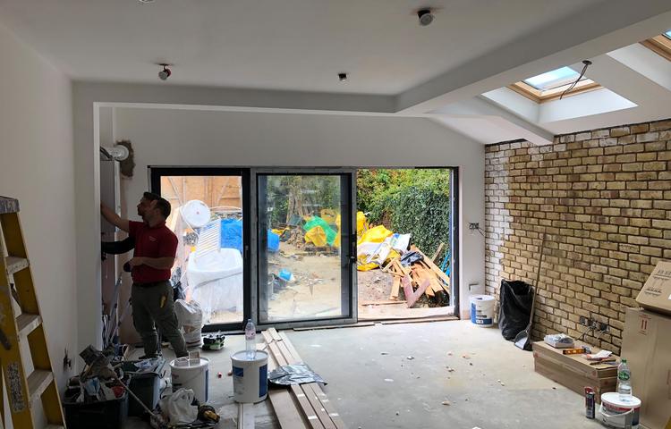 Open-plan kitchen construction and garden doors in Lewisham