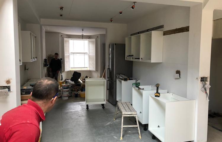 Installing cabinets in the open-plan kitchen in Lewisham