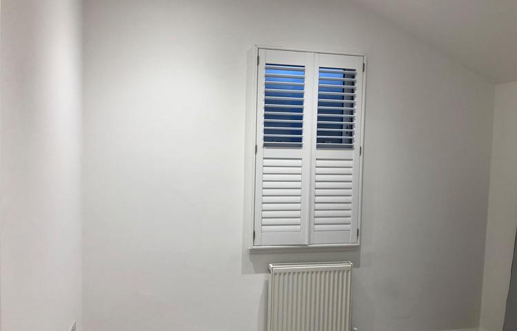 Refurbished upper-floor room with radiator and shutters in Lewisham