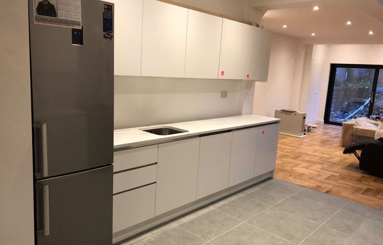 White kitchen cabinetry and newly laid flooring in Lewisham